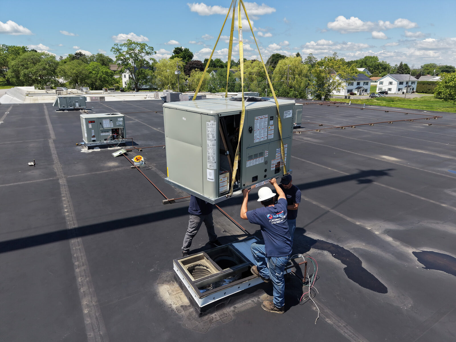 E.T. Harris technicians servicing rooftop HVAC equipment